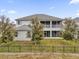 Two-story home featuring a screened-in porch, fenced backyard, and lush landscaping at 16737 Meadows St, Clermont, FL 34714