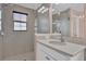 Modern bathroom featuring a walk-in shower, vanity with sink, and neutral tile at 16737 Meadows St, Clermont, FL 34714