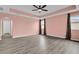 Bright bedroom featuring tray ceiling, wood-look floors, and large windows with curtains at 16737 Meadows St, Clermont, FL 34714