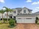 Elegant two-story home boasts a three-car garage, lush landscaping, and a brick driveway at 16737 Meadows St, Clermont, FL 34714