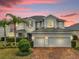 Elegant two-story home boasts a three-car garage, lush landscaping, and a brick driveway at 16737 Meadows St, Clermont, FL 34714