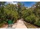 Scenic view of a peaceful walking path, lined with lush greenery and equipped with benches for relaxation at 16737 Meadows St, Clermont, FL 34714