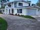 White two-story house with a gravel driveway, landscaping, and attached garage at 219 Nob Hill Cir, Longwood, FL 32779