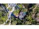 Overhead aerial view of a large home on a wooded lot with mature landscaping and a paver driveway at 2395 Windward Cv, Kissimmee, FL 34746