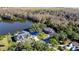 Aerial view of two waterfront homes with mature trees and landscaping on a beautiful lake at 2395 Windward Cv, Kissimmee, FL 34746