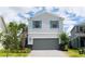 Two-story house featuring gray siding, gray garage door, and blue shutters at 2472 Dubai St, Kissimmee, FL 34747