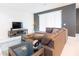 Living room featuring L-shaped sectional sofa and a large TV at 2472 Dubai St, Kissimmee, FL 34747