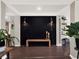 Modern entryway with a statement black feature wall and wood bench at 2583 Grassmoor Loop, Apopka, FL 32712