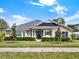 Tan house with gray roof, landscaping, and black shutters at 2583 Grassmoor Loop, Apopka, FL 32712