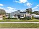 Tan house with gray roof, landscaping, and black shutters at 2583 Grassmoor Loop, Apopka, FL 32712