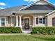 Front entrance with black door and white columns at 2583 Grassmoor Loop, Apopka, FL 32712