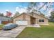 Tan house with white garage doors and landscaping at 2749 Abney Ave, Orlando, FL 32833