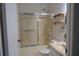 Bathroom with neutral walls, wood shelving, shower and marble top sink at 32512 Oak Park Dr, Leesburg, FL 34748