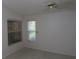 Bright bedroom featuring neutral carpet, white walls, and two sunny windows at 32512 Oak Park Dr, Leesburg, FL 34748