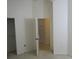 Bedroom with open closet and door leading to a tiled hallway, offering storage and flow at 32512 Oak Park Dr, Leesburg, FL 34748