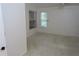 A bright bedroom featuring neutral carpet, white walls, and two sunny windows at 32512 Oak Park Dr, Leesburg, FL 34748