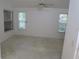 Bright, carpeted bedroom features two windows and a ceiling fan at 32512 Oak Park Dr, Leesburg, FL 34748