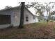 Exterior side view of home featuring well-maintained lawn, mature trees and shrubs at 32512 Oak Park Dr, Leesburg, FL 34748