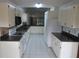 Bright kitchen featuring white cabinetry, tile floors, and plentiful counter space at 32512 Oak Park Dr, Leesburg, FL 34748