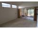 This is a carpeted living room featuring windows, sliding glass doors, and natural light at 32512 Oak Park Dr, Leesburg, FL 34748