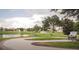 Picturesque view of pond, benches, and walking path adds beauty and relaxation to the community at 32512 Oak Park Dr, Leesburg, FL 34748
