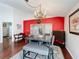 Bright dining room with a chandelier and red accent wall, adjacent to the kitchen at 3713 Doune Way, Clermont, FL 34711