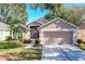 Single-story house featuring a two-car garage and manicured lawn at 3713 Doune Way, Clermont, FL 34711