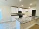 Modern kitchen with white cabinets, granite countertops and stainless steel appliances at 4464 Sagefield Dr, Harmony, FL 34773