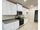 Modern kitchen with white cabinets, granite countertops and stainless steel appliances at 4464 Sagefield Dr, Harmony, FL 34773