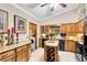 Functional kitchen featuring tile backsplash, granite countertops, wooden cabinets, and an island with wine rack and included laundry closet at 489 Sugar Ridge Ct, Longwood, FL 32779