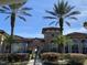 Community clubhouse with palm trees and walkway at 5548 Metrowest Blvd # 101, Orlando, FL 32811