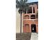A stucco condo building with multiple levels and a landscaped entrance featuring palm trees at 5548 Metrowest Blvd # 101, Orlando, FL 32811