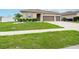 House exterior featuring a two-car garage and lush landscaping at 5681 Western Sun Dr, St Cloud, FL 34771