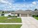 Two-story house with brown garage doors and landscaped yard at 5681 Western Sun Dr, St Cloud, FL 34771