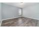 Spacious bedroom with wood-look flooring and a window at 5791 Covington Cove Way, Orlando, FL 32829