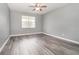 Bedroom with ceiling fan and grey wood-look flooring at 5791 Covington Cove Way, Orlando, FL 32829