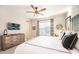 Relaxing bedroom showcasing a ceiling fan, TV, dresser, and comfortable king size bed at 7925 Putting Green Way, Reunion, FL 34747