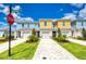 Charming townhomes feature colorful exteriors, well-manicured lawns, and paved driveways under a sunny sky at 7925 Putting Green Way, Reunion, FL 34747