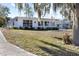 A bright white one-story home showcasing an ample front yard and picture windows for natural light at 814 S Lakeshore Blvd, Lake Wales, FL 33853