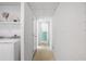 Hallway leading to a laundry area and bathroom with white brick walls at 814 S Lakeshore Blvd, Lake Wales, FL 33853
