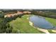 Scenic aerial view showcasing a stunning golf course, serene lake, and upscale residential buildings at 8189 Roseville Rd, Davenport, FL 33896