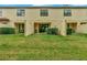 Backyard view of patios with green grass and trimmed hedges at 8189 Roseville Rd, Davenport, FL 33896