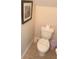 Neat half bathroom with a standard toilet, neutral wall color, and decor art at 8189 Roseville Rd, Davenport, FL 33896