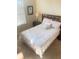 Comfortable bedroom featuring a wooden headboard, plush pillows, and a bedside table with a lamp at 8189 Roseville Rd, Davenport, FL 33896