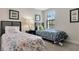 Charming bedroom featuring twin beds, a nightstand, and natural light from a window at 8189 Roseville Rd, Davenport, FL 33896