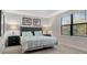 Bedroom offers a large window, neutral walls, tray ceiling, and two end tables with lamps at 8189 Roseville Rd, Davenport, FL 33896