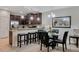 Well-lit dining area featuring dark wood cabinets, stainless steel appliances, and a table with seating for four at 8189 Roseville Rd, Davenport, FL 33896