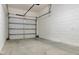 A clean, empty one car garage features white walls and concrete flooring at 8189 Roseville Rd, Davenport, FL 33896