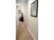 Carpeted hallway view into bedroom with bed and nightstand at 8189 Roseville Rd, Davenport, FL 33896