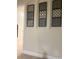Hallway features decorative wall art, neutral paint, and a glimpse into adjacent rooms at 8189 Roseville Rd, Davenport, FL 33896